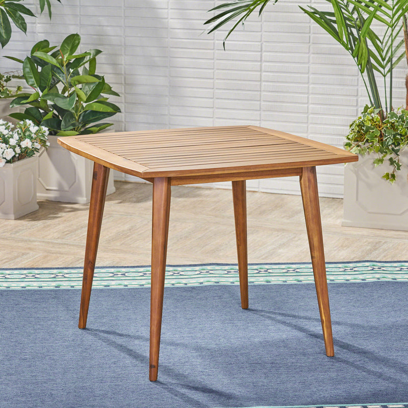 Modern indoor square dining table by Noble House with acacia wood surface and toothpick leg design, ideal for contemporary dining rooms.