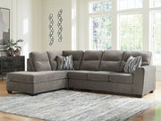 Benchcraft Olten Stationary Sectional sofa with plush cushions, neutral fabric, and modern design in a cozy living room setting.
