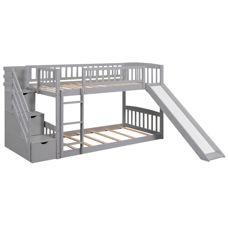 Gray DreamHaus twin over twin bunk bed with stairway, two drawers, and slide, featuring a sturdy design and cozy sleeping area.