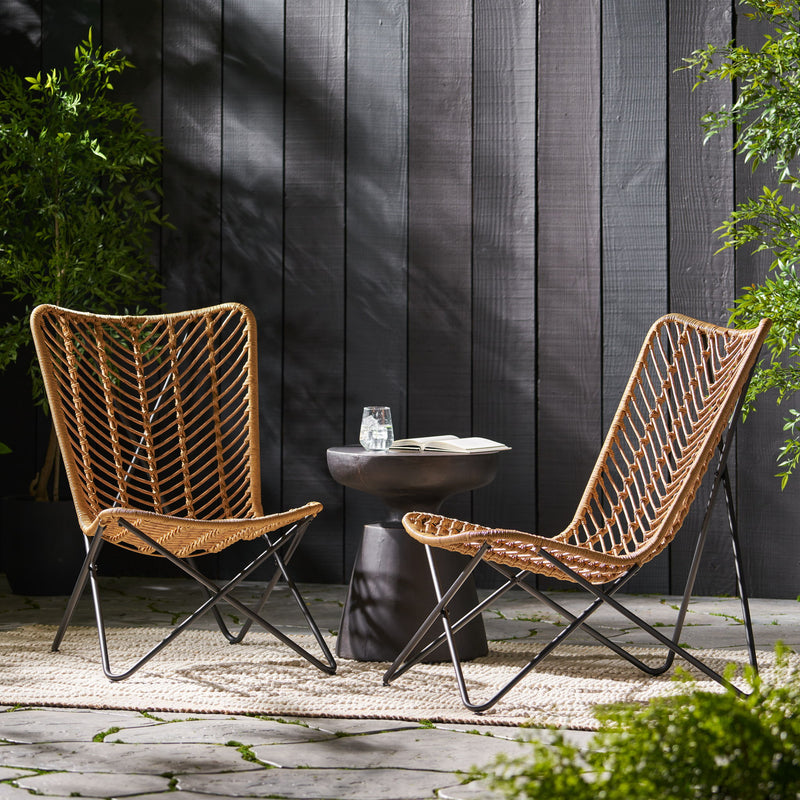 Set of two light brown wicker chairs with geometric cross metal bases, ideal for indoor or outdoor seating.