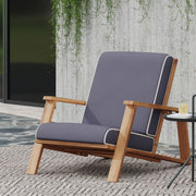 Outdoor Noble House patio lounge chair with armrests, featuring a comfortable cushioned seat and stylish design for outdoor relaxation.