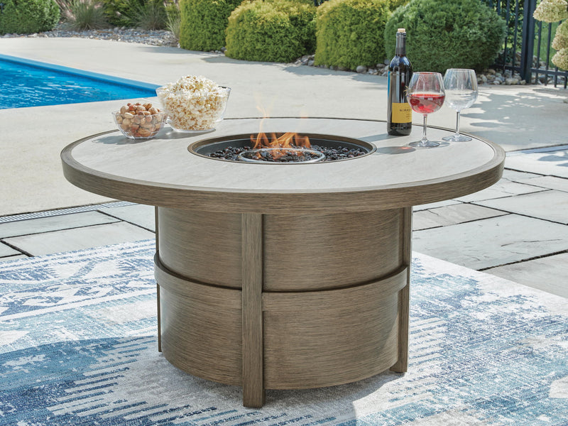 Round beige fire pit table by Signature Design by Ashley, ideal for outdoor gatherings and cozy evenings.