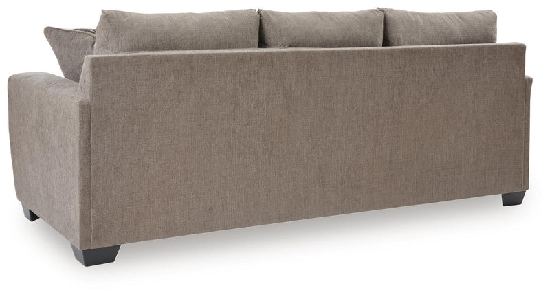 Benchcraft stationary sofa from Loreo collection, featuring plush cushions and modern design in a cozy living room setting.