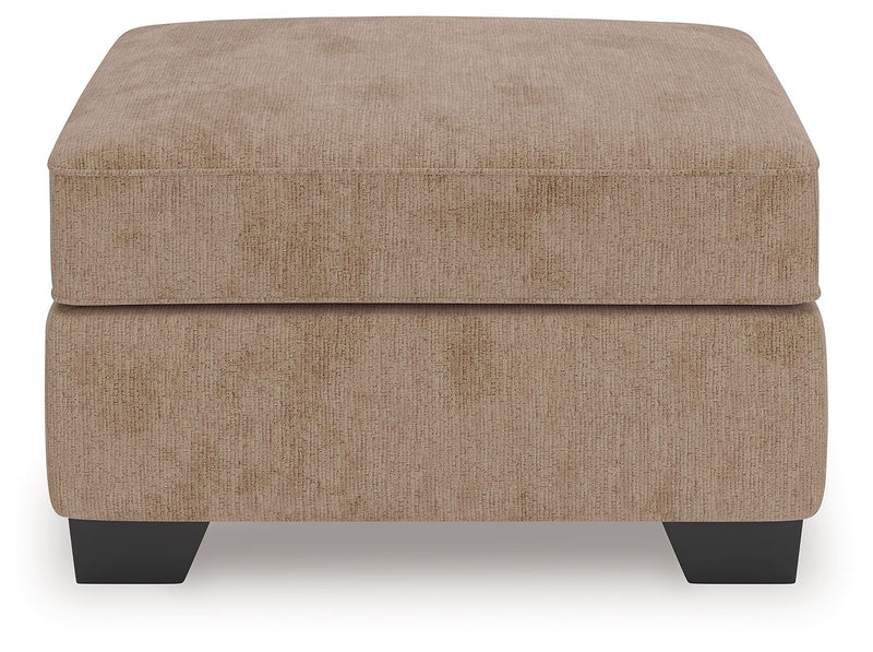 Benchcraft® Olten accent ottoman with plush fabric and wooden legs, perfect for living room decor and extra seating.