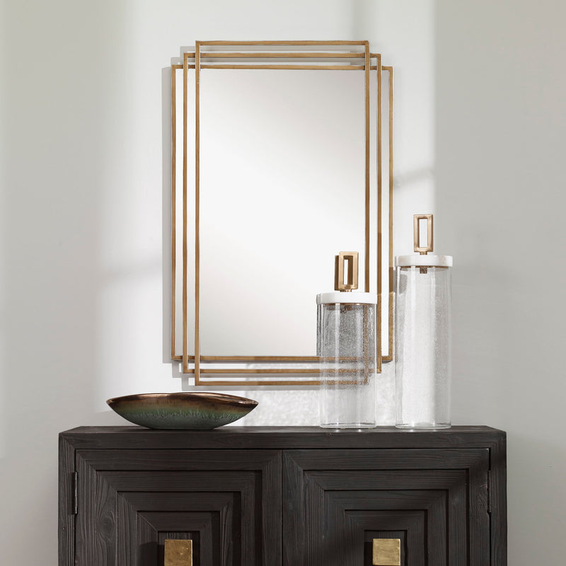 Uttermost Amherst wall mirror with elegant frame, reflecting light and adding style to a modern decor space.