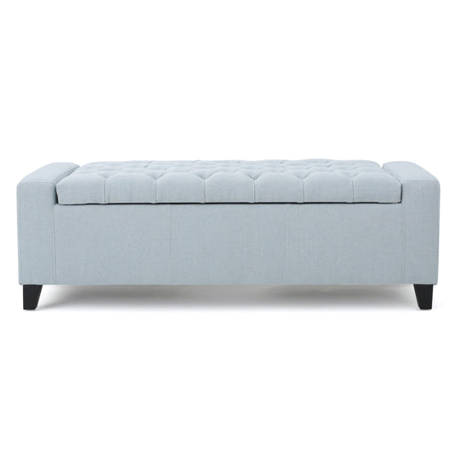 Noble House Guernsey storage ottoman with tufted top, beige fabric, and sturdy wooden legs, serving as both seat and storage.