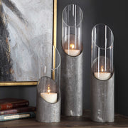 Set of three Uttermost Karter iron and glass candleholders in pearl silver and dark gray with elegant candle inserts.