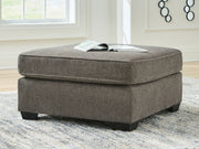 Benchcraft® Olten accent ottoman with cushioned top and wooden legs, ideal for living room or bedroom decor.
