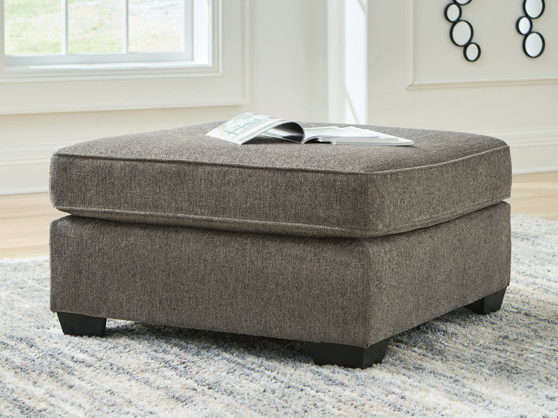 Benchcraft® Olten accent ottoman with cushioned top and wooden legs, ideal for living room or bedroom decor.