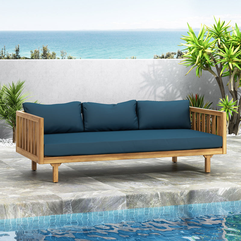 Noble House Claremont 3-seater teak acacia wood daybed with water-resistant cushions and plush seating.