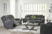 Signature Design by Ashley Frohn reclining living room sofa with plush fabric, padded armrests, and built-in recliner mechanism.