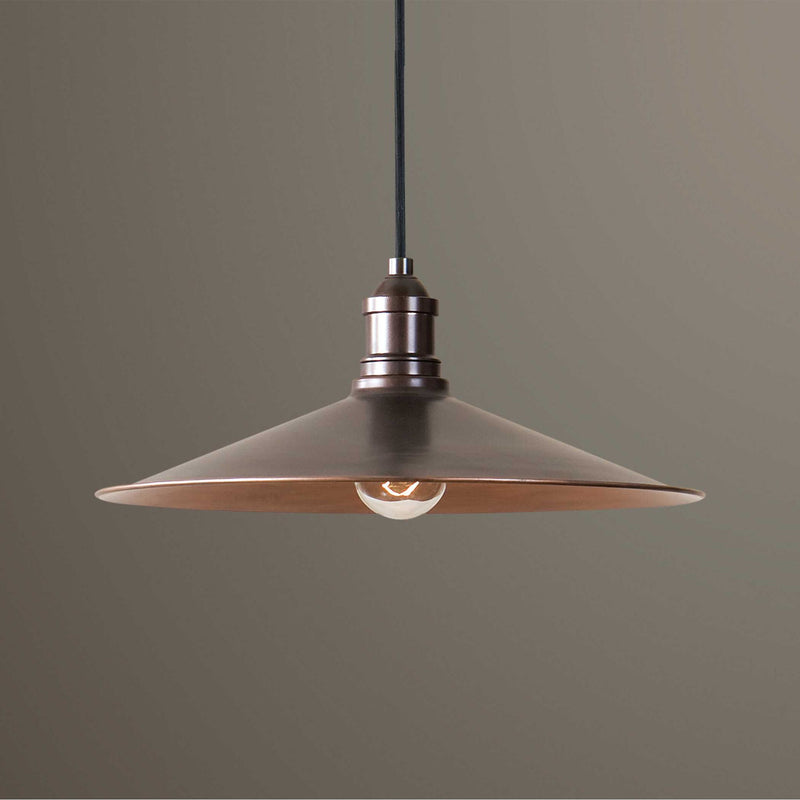 Uttermost Barnstead 1-light copper pendant lighting with light brown finish, hanging from a ceiling with a warm, inviting glow.