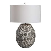 Uttermost Cyprien gray and white table lamp with a sleek, modern design and a cylindrical base on a wooden surface.