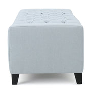 Noble House Guernsey storage ottoman with tufted top, beige fabric, and sturdy wooden legs, serving as a versatile accent piece.