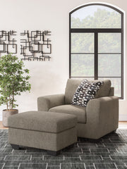 Benchcraft Triston-Peaks living room set with stationary chair and ottoman, upholstered in neutral fabric with plush cushions.
