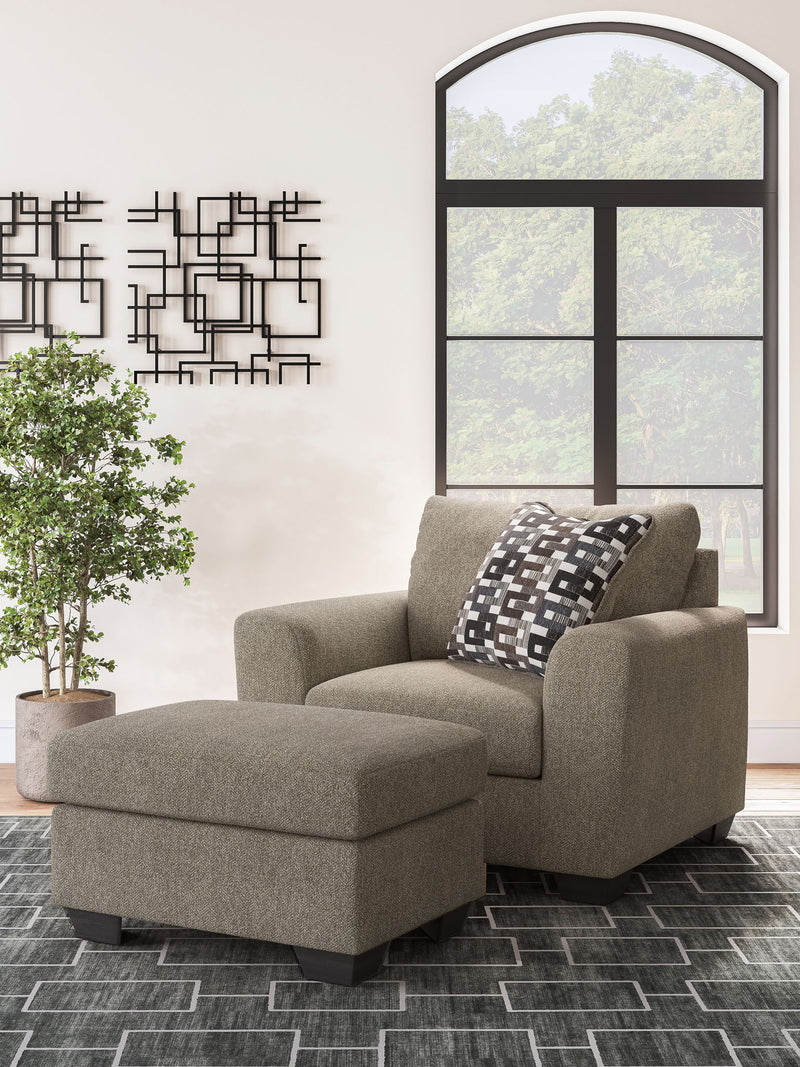 Benchcraft Triston-Peaks living room set with stationary chair and ottoman, upholstered in neutral fabric with plush cushions.
