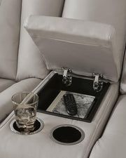 Signature Design by Ashley Glide Reclining Loveseat with console in coin fabric, featuring plush cushions and integrated armrest storage.