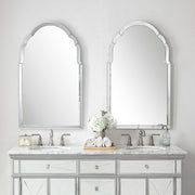 Uttermost Brayden frameless arched wall mirror with pearl silver finish, showcasing a sleek, modern design on a wall.