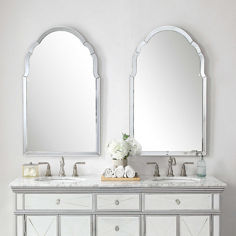 Uttermost Brayden frameless arched wall mirror with pearl silver finish, showcasing a sleek, modern design on a wall.