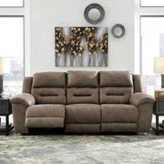 Signature Design by Ashley reclining sofa from Stoneland collection showing plush cushions and reclining feature in a modern living room setting.