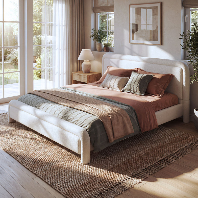 Artistry At Home upholstered platform bed with curved headboard and wood slats support, showcasing a modern, padded design.