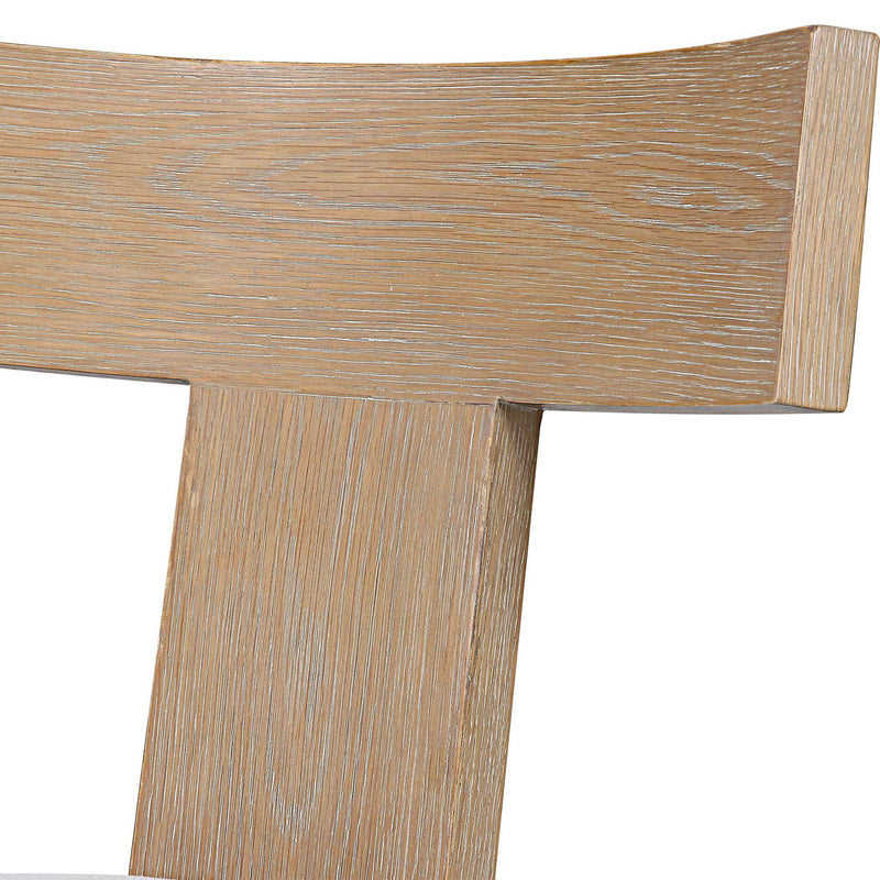 Uttermost Idris armless side chair with upholstered seat and wooden legs, showcasing modern design and neutral fabric.