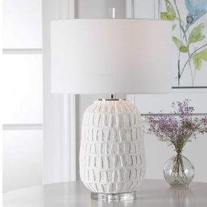 White textured Caelina table lamp by Uttermost with a modern design, featuring a cylindrical base and fabric shade.