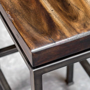 Industrial Beck counter height bar stool by Uttermost with metal frame and wooden seat, 24-27 inches tall.