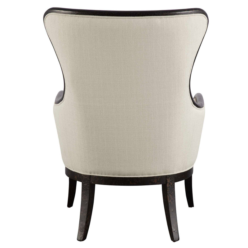 Beige and dark brown wing back armchair by Uttermost with plush upholstery and wooden legs, showcasing elegant, classic design.