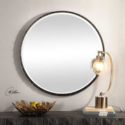 Round black wall mirror by Uttermost, featuring a sleek modern design and a black frame, ideal for contemporary decor.