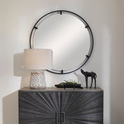 Black round iron accent mirror by Uttermost with a sleek, minimalist design, mounted on a wall.