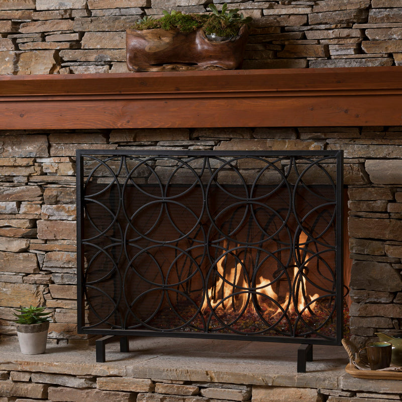 Noble House Thayer single panel iron fireplace screen with geometric design, featuring a black metal finish and decorative cutouts.