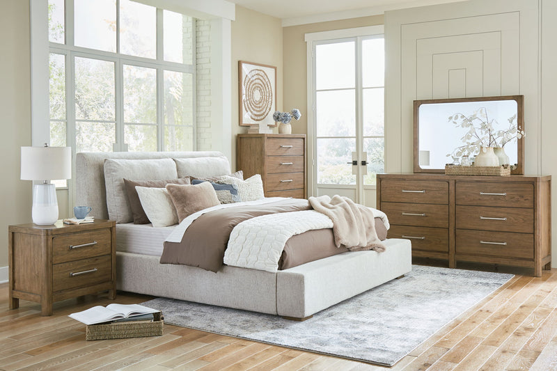 Signature Design by Ashley Cabalynn upholstered bedroom set with a bed, nightstands, and dresser in a cozy bedroom scene.
