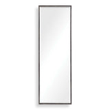Uttermost Callan black leaner mirror with sleek frame, standing tall against a wall in a modern interior setting.