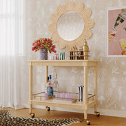 TOV Furniture Slosh bar cart in natural ash wood with two shelves and metal frame, modern design for stylish beverage storage.