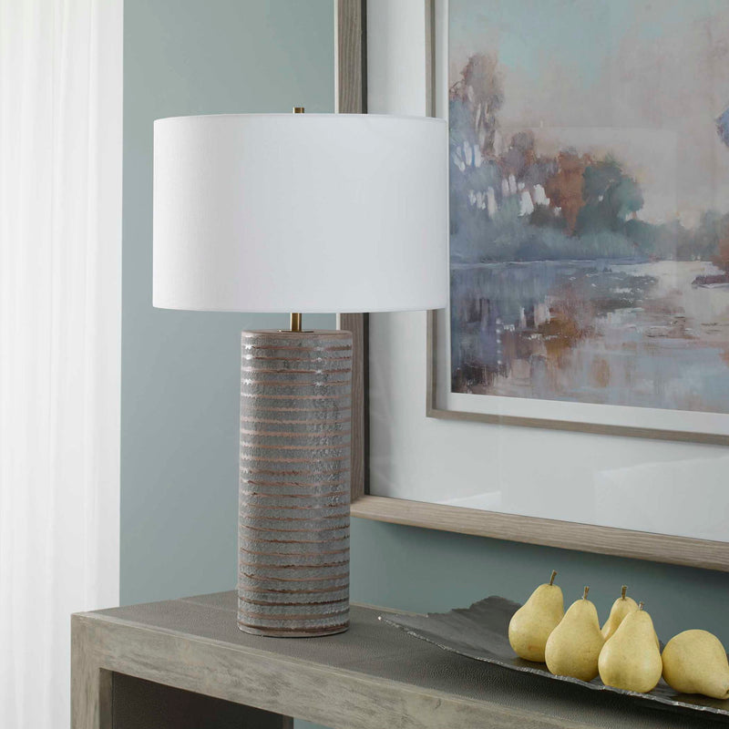 Uttermost Monolith gray table lamp with a sleek modern design, featuring a textured base and a simple fabric shade.