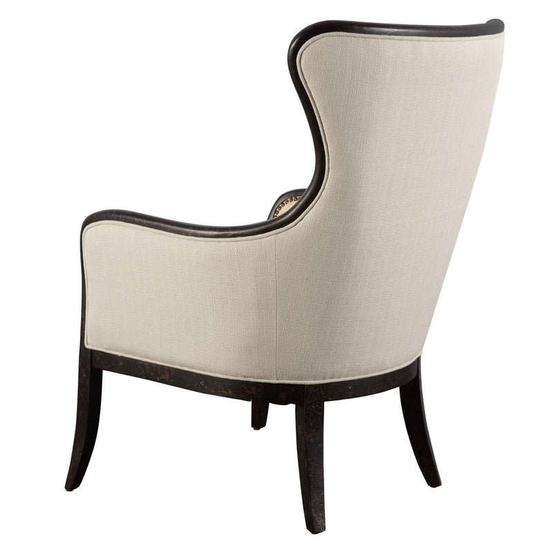 Uttermost Sandy wing back armchair in beige and dark brown fabric with plush cushioning and curved wooden legs.