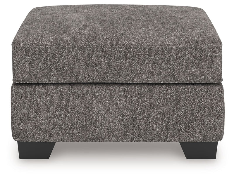 Olten Benchcraft® accent ottoman with plush fabric and wooden legs, serving as a stylish, versatile footrest or small table.