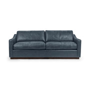 Classic Home Aspen stationary sofa with plush beige upholstery and rolled arms in a cozy living room setting.