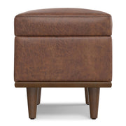 Small Simpli-Home Shiloh storage ottoman with cushioned top and wooden legs for versatile living room or bedroom storage.
