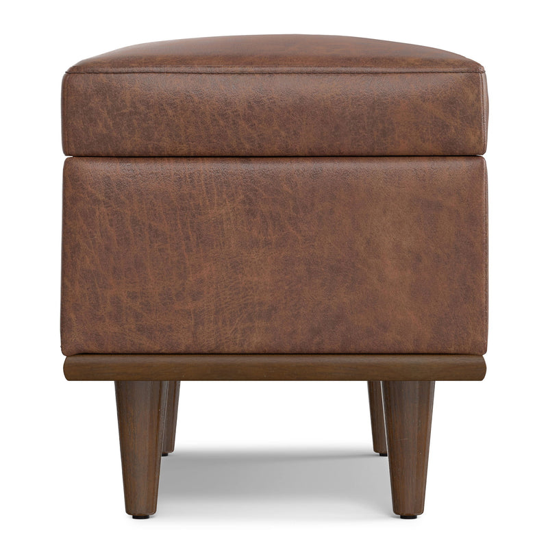 Small Simpli-Home Shiloh storage ottoman with cushioned top and wooden legs for versatile living room or bedroom storage.