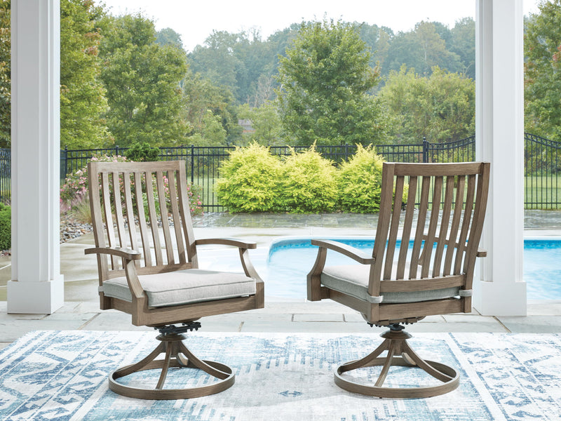 Pair of Signature Design by Ashley Rainier Ranch swivel chairs with beige cushions, brown wood finish, and comfortable seating.