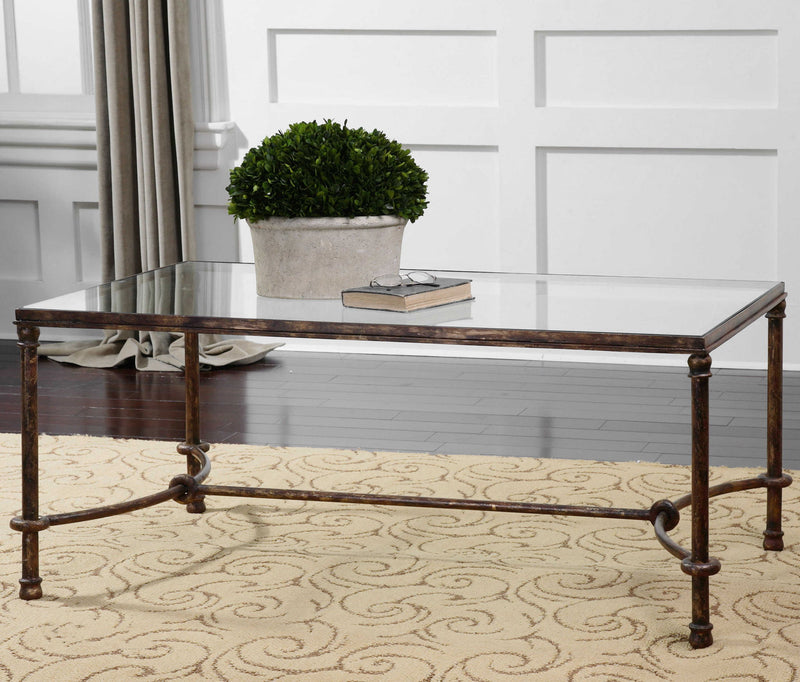 Uttermost Warring iron coffee table with a rustic, industrial design featuring a sturdy metal frame and wooden tabletop.