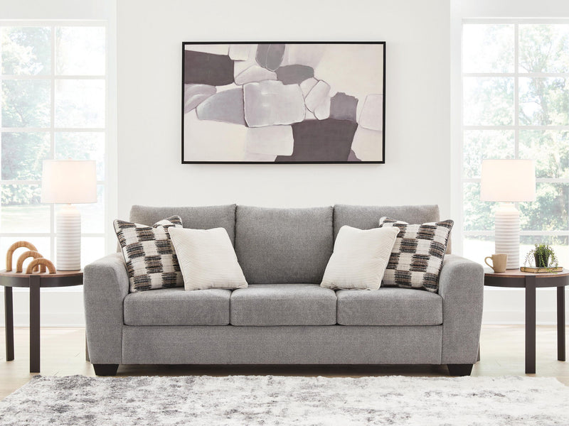 Benchcraft® Loreo stationary sofa with plush fabric and wide armrests, shown in a modern living room setting.