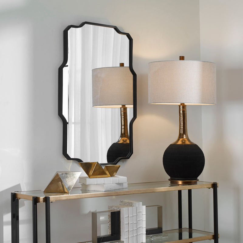 Black Casmus Iron Wall Mirror by Uttermost with a sleek, round frame hanging on a minimalist wall.