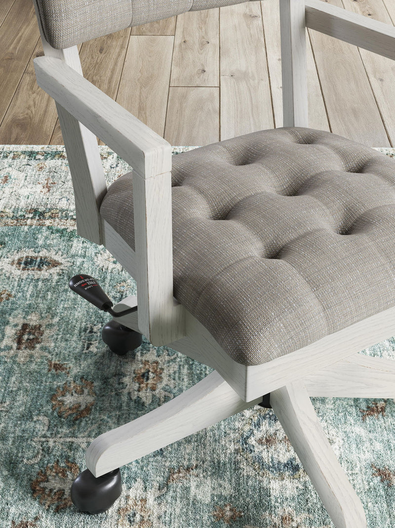 Signature Design by Ashley Robbinsdale home office desk chair in antique white with a cushioned seat and wooden armrests.