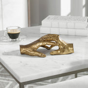Gold "Hold My Hand" sculpture by Uttermost, featuring a detailed figurine of two hands gently clasped together.