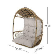 Light brown wicker hanging chair with beige cushions, suspended by an 8-foot chain, ideal for outdoor or indoor relaxing spaces.