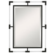 Uttermost Balkan iron wall mirror with round frame, decorative metal design, hanging on a neutral wall interior.