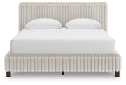 Signature Design by Ashley Zuraleus upholstered bed with a padded headboard and neutral fabric, showcasing a modern bedroom style.